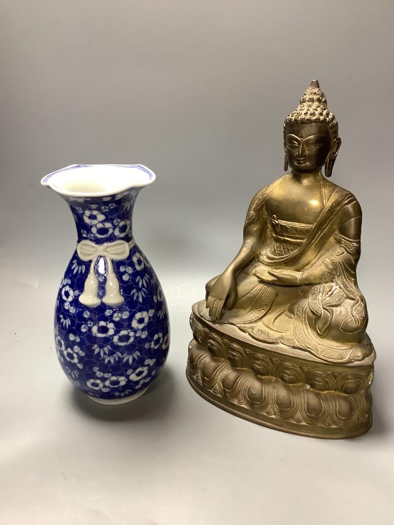 A bronze figure of a seated Buddha and a Japanese blue and white ovoid vase, of 'sack' form with applied tied cord and wavy rim, tallest 31cm H 30cm & 23cm